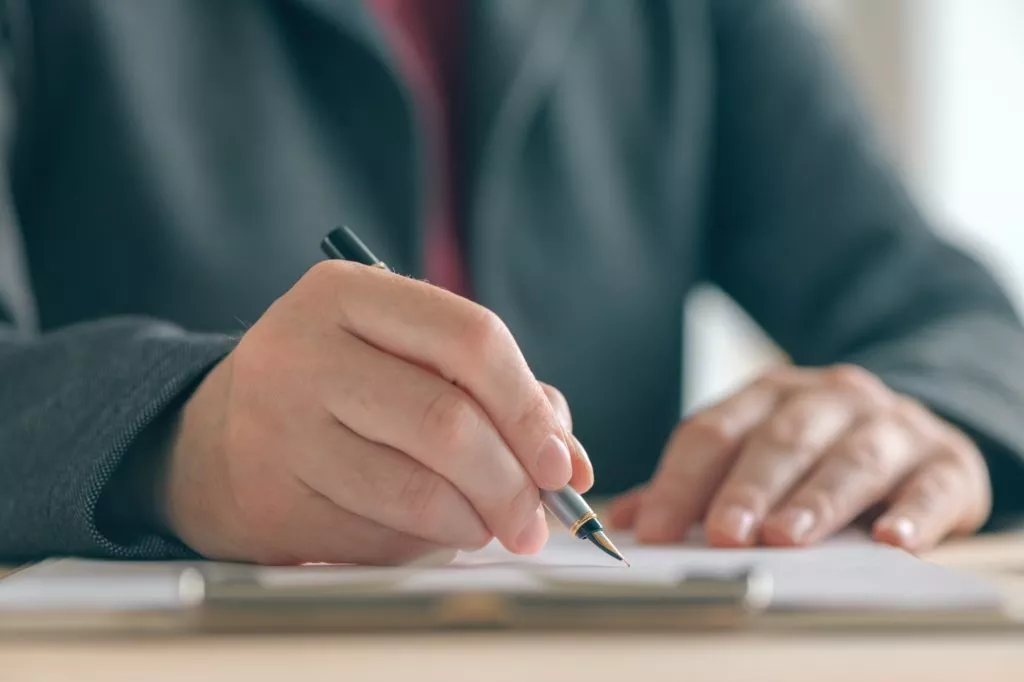 Close up of businesswoman hands signing contract and business ag