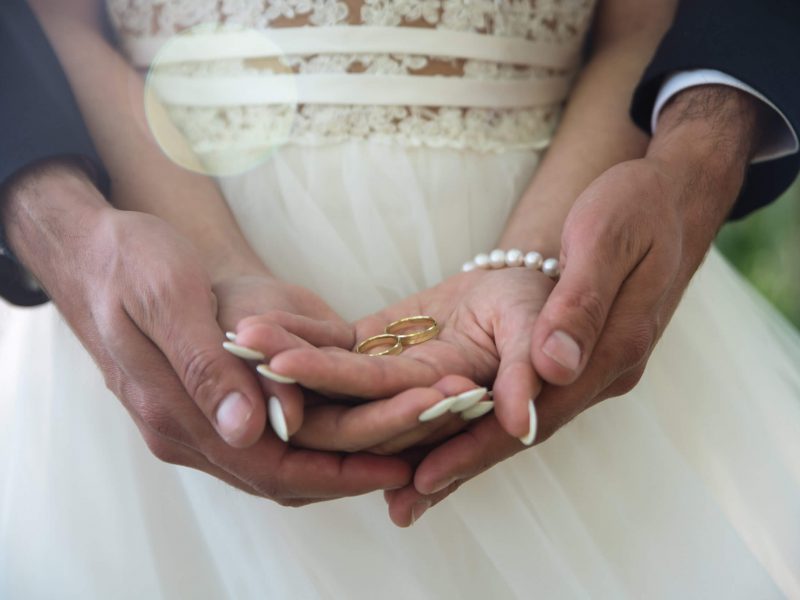 Two golden wedding rings on bride and groom's palms. Wedding rings on the palm