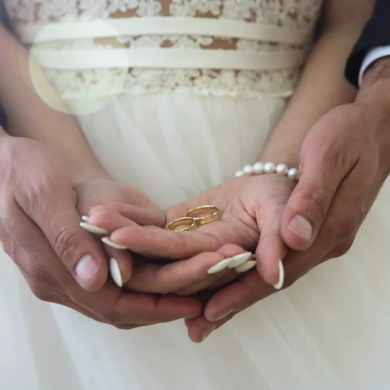 Two golden wedding rings on bride and groom's palms. Wedding rings on the palm